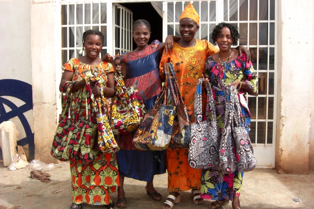 Local tailors presenting their finished product, custom-made shoulder bags. Association Couturière pour la Relance de la Femme Rural, Fungurume, November 2011.